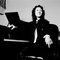 Japanese pianist and conductor Mitsuko Uchida posed seated at a piano in 2002.