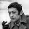 Gainsbourg smoking pensively whilst wearing one of his signature Paletot coats