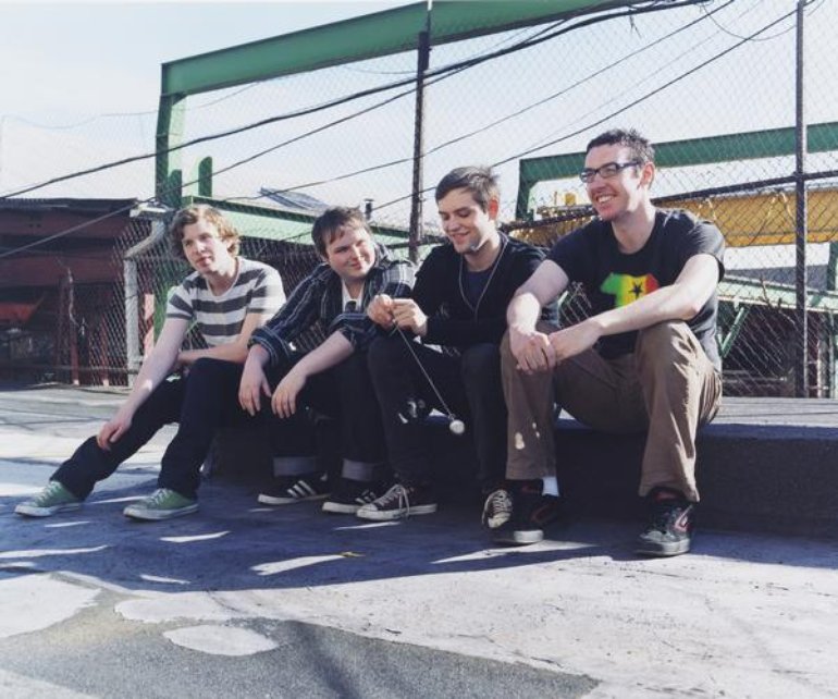 4 dudes hanging out on a rooftop