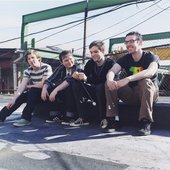 4 dudes hanging out on a rooftop