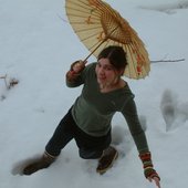 Mariah walking in snow with umbrella