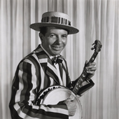 Nappy Lamare holding a banjo while sitting and smiling.png