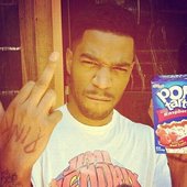 Cudi flipping off the camera while holding a box of pop tarts