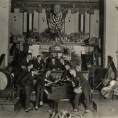 Leroy Smith and his orchestra posing around piano with musical instruments-crop.jpg