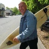 Matthew Larkin Cassell, walking his surfboard across Miller Avenue in Mill Valley,…