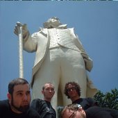 band photo in front of some statue of some dude