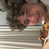 Keyboard player eating a Halal snack pack from Lane Cove