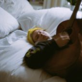nathan in bed with a guitar