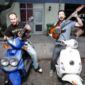 Tim and Luke on Mopeds with guitars
