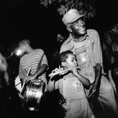 \"Othar Turner shows his pride as granddaughter Sharde performs on his cane fife at a picnic and grandsons Rodney, Andre and Aubrey play the drums\"