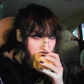Dogtreatz eating a sandwich in a car