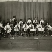 Violinist Leroy Smith and his orchestra posing on stage with musical instruments-crop.jpg