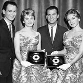 1959: The Fleetwoods with Dick Clark, receiving their gold records for “Come Softly to Me” and “Mr. Blue.”
